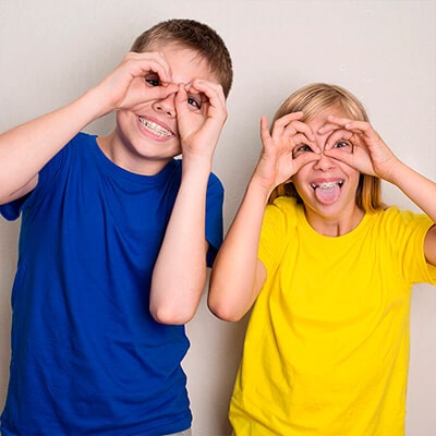 Two young kids make silly faces at the camera