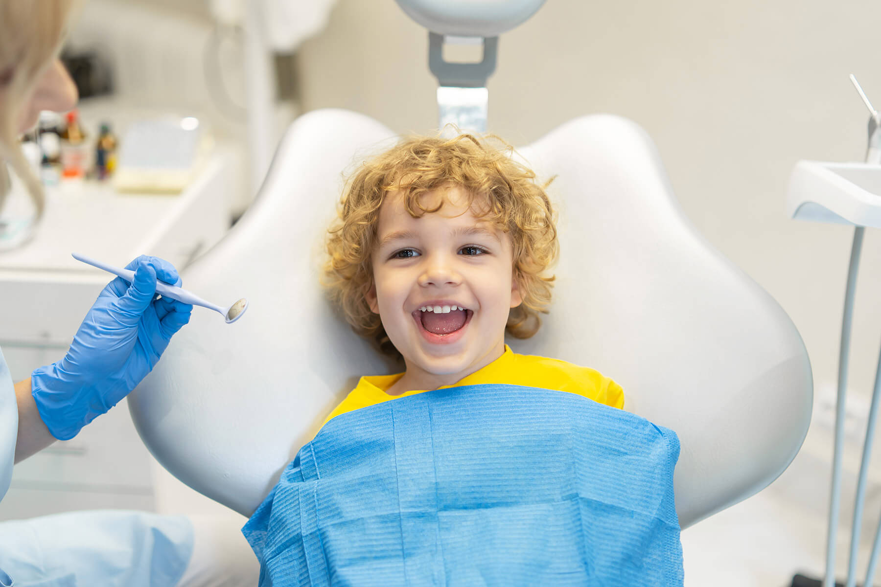 A young boy sits in a dental exam chair during a checkup