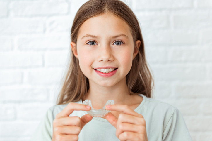 girl holding invisalign